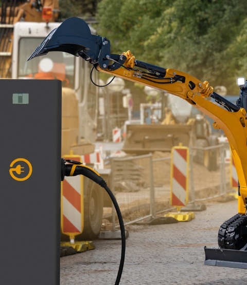 Rechargeable yellow and black construction machine with charging station