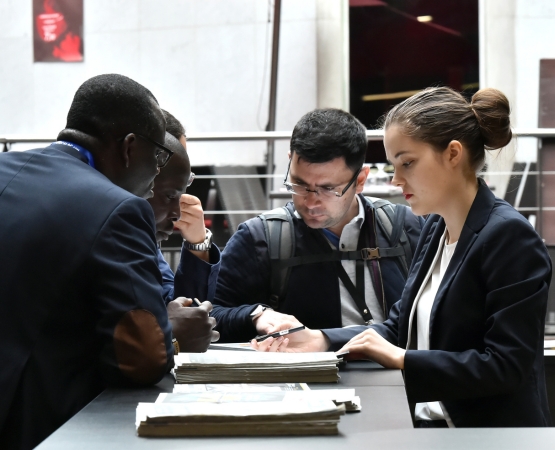 Group of people having an exchange by consulting a document